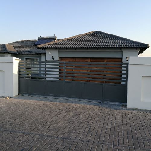 Automated steel driveway sliding gate with timber slat inlay installed in Brakpan